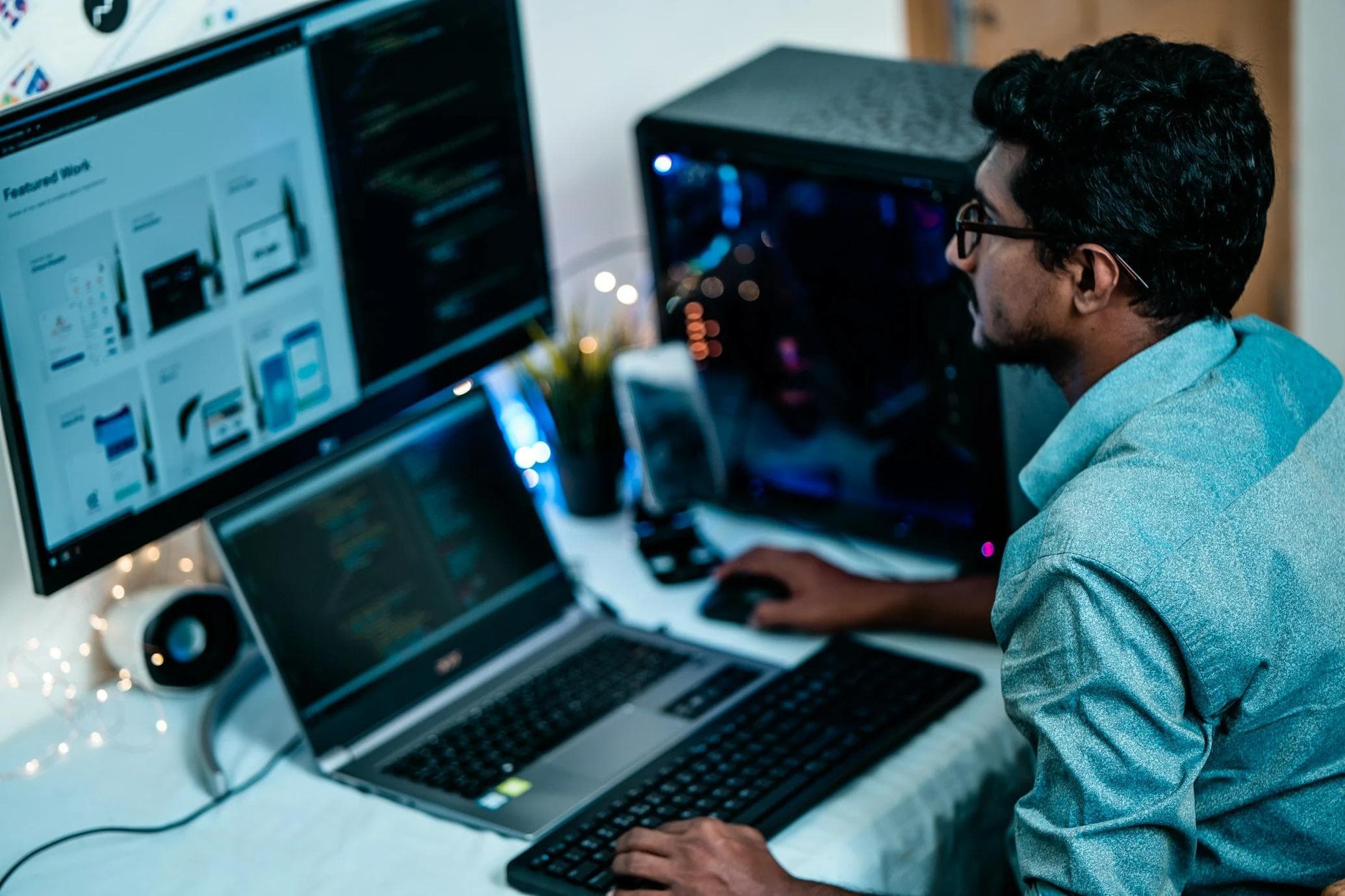 Indian man working on computer and laptop